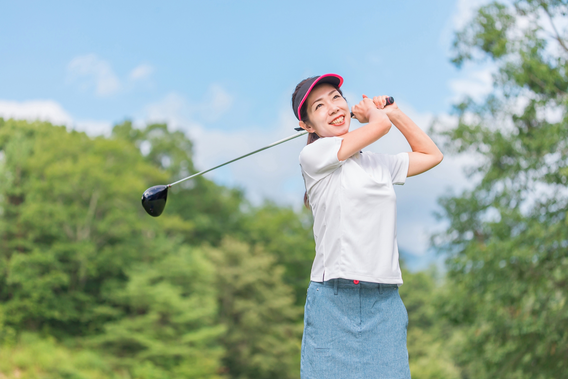 ゴルフをする笑顔の女性(ゴルフコンペ)
